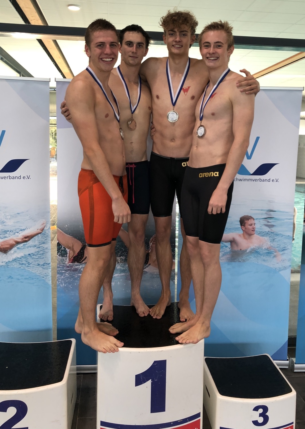 4 Schwimmer auf der Siegertreppe